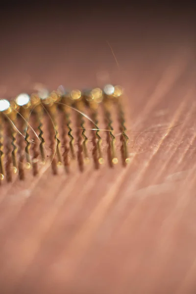 Dettaglio pettine capelli dorati con capelli biondi su divano rosa . — Foto Stock
