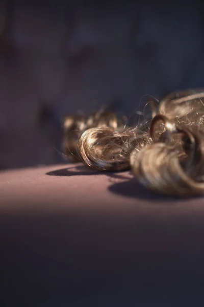 Каштановые вьющиеся волосы лежат на розовом диване . — стоковое фото