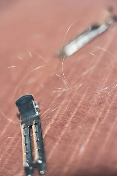 Pinces à cheveux avec des cheveux lâches couchés sur un canapé rose . — Photo