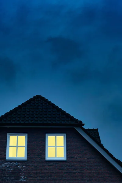 Landhaus mit beleuchteten Fenstern in der Dämmerung. — Stockfoto