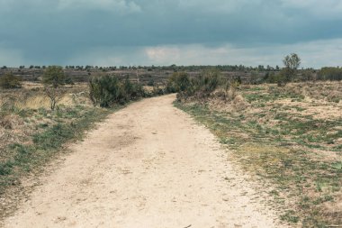 Bulutlu gökyüzü altında engebeli manzara Kir yol.