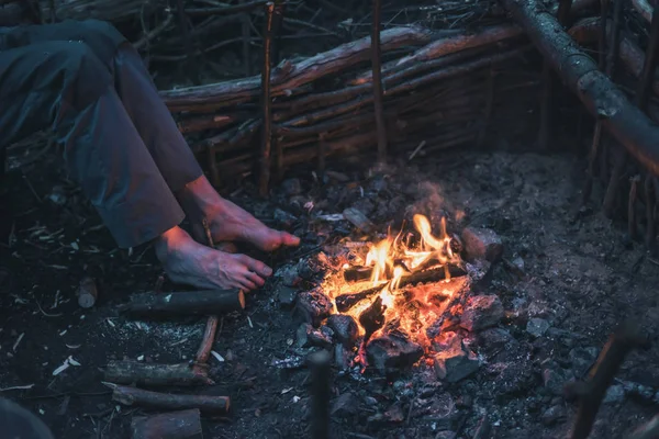 Männliche Füße wärmen sich am Lagerfeuer. — Stockfoto