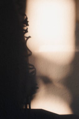 Kapalı beyaz duvarda gölgeler ve akşam güneş ışığı.