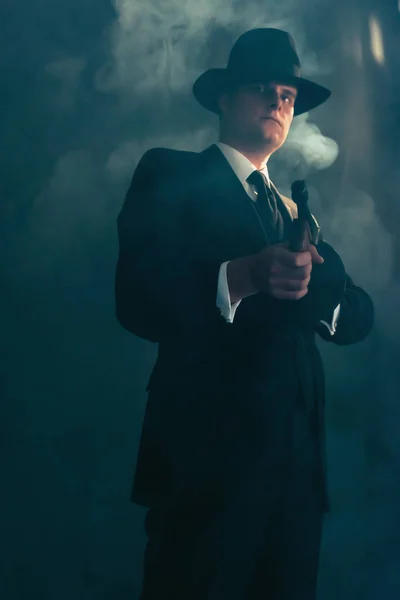 Gángster retro en sombrero en los disparos nocturnos brumosos con ametralladora . — Foto de Stock