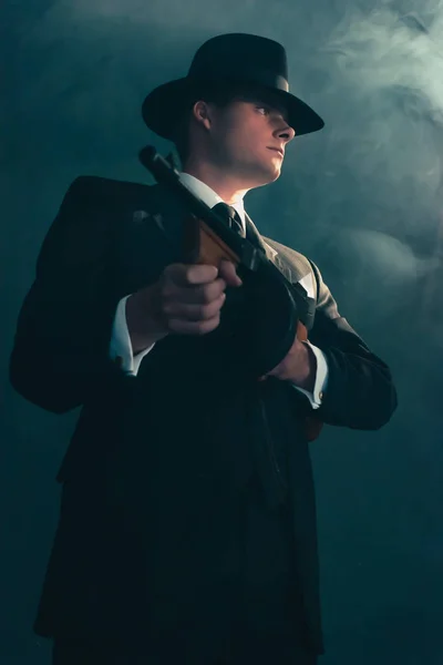 Retro gangster stands met machinegeweer in mist. — Stockfoto