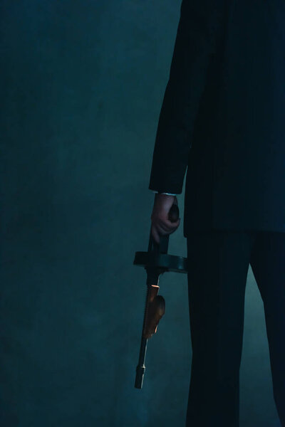 Retro gangster holding machine gun.