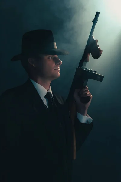 Ретро-гангстер стоит с пулеметом в тумане . — стоковое фото