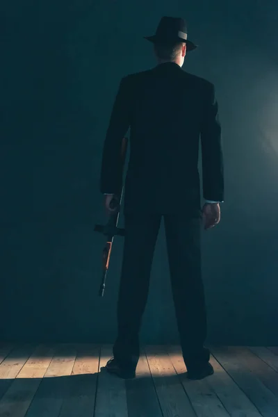 Ретро-гангстер стоит с пулеметом. Вид сзади . — стоковое фото