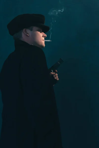 Retro gangster met sigaret houdt pistool. Zijaanzicht. — Stockfoto