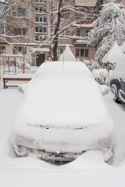 Otoparktaki kar fırtınasında araçlar karla kaplı.