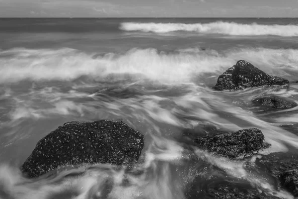 石のビーチと美しい海の風景 長時間露光ショットします 黒と白 — ストック写真