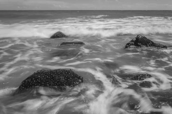 石のビーチと美しい海の風景 長時間露光ショットします 黒と白 — ストック写真