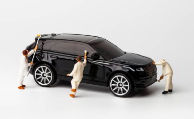 Oto yıkamada otomobil temizleyen minyatür insanlar