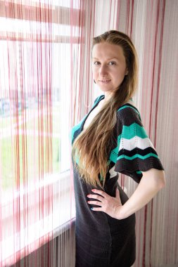 bir pencere yakınında güzel bir kadın portresi. o şu kamera gülümseyen önünde duran ve mutlu görünüyordu