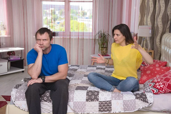 family difficulties - husband and wife in a quarrel. Family conflict, a quarrel between dissatisfied husband and wife in a room on the couch and bed