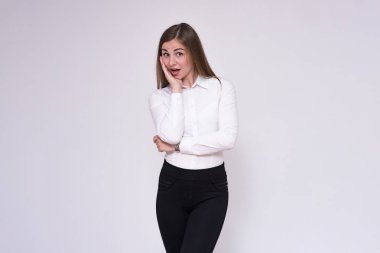 beyaz bir arka planda beyaz gömlekli farklı pozlar farklı duygular ile güzel bir esmer kız portresi. O şu kamera gülümseyen önünde duran ve mutlu görünüyordu