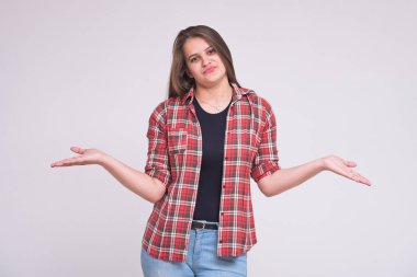 farklı duygular ile farklı pozlar kot pantolon beyaz bir arka plan üzerinde güzel bir esmer kız portresi. O şu kamera gülümseyen önünde duran ve mutlu görünüyordu
