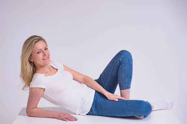 Portrait Beautiful Blonde Girl White Background Lying Table She Lies — Stock Photo, Image