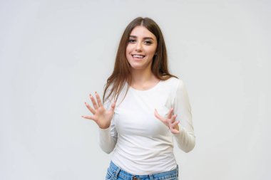 Stüdyo bir gülümseyen mutlu güzel esmer kız beyaz arka plan üzerinde portresi. Doğrudan çeşitli teşkil etmektedir kamera önünde duruyor.