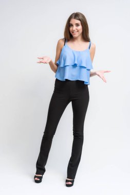 Stüdyo bir gülümseyen mutlu güzel esmer kız beyaz arka plan üzerinde portresi. Doğrudan çeşitli teşkil etmektedir kamera önünde duruyor.