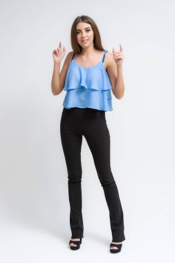 Stüdyo bir gülümseyen mutlu güzel esmer kız beyaz arka plan üzerinde portresi. Doğrudan çeşitli teşkil etmektedir kamera önünde duruyor.