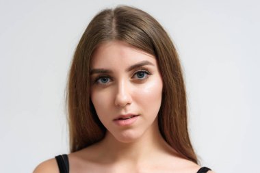 Stüdyo bir gülümseyen mutlu güzel esmer kız beyaz arka plan üzerinde portresi. Doğrudan çeşitli teşkil etmektedir kamera önünde duruyor.