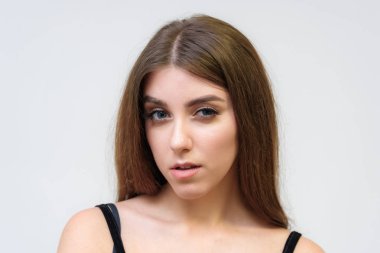 Stüdyo bir gülümseyen mutlu güzel esmer kız beyaz arka plan üzerinde portresi. Doğrudan çeşitli teşkil etmektedir kamera önünde duruyor.