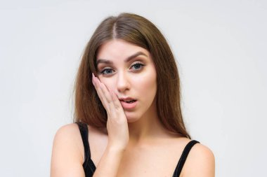 Stüdyo bir gülümseyen mutlu güzel esmer kız beyaz arka plan üzerinde portresi. Doğrudan çeşitli teşkil etmektedir kamera önünde duruyor.