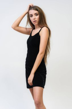 Stüdyo bir gülümseyen mutlu güzel esmer kız beyaz arka plan üzerinde portresi. Doğrudan çeşitli teşkil etmektedir kamera önünde duruyor.