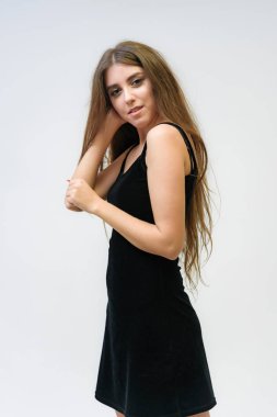 Stüdyo bir gülümseyen mutlu güzel esmer kız beyaz arka plan üzerinde portresi. Doğrudan çeşitli teşkil etmektedir kamera önünde duruyor.