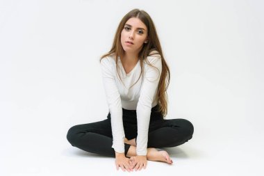 Stüdyo bir gülümseyen mutlu güzel esmer kız konuşuyor ve katta oturan beyaz bir arka plan üzerinde portresi. Çeşitli teşkil etmektedir kamera önünde doğru söylüyor.