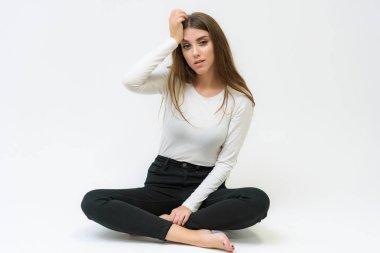 Stüdyo bir gülümseyen mutlu güzel esmer kız konuşuyor ve katta oturan beyaz bir arka plan üzerinde portresi. Çeşitli teşkil etmektedir kamera önünde doğru söylüyor.