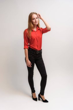 Stüdyo portre fotoğraf gülümseyen güzel bir kızın uzun saçlı beyaz bir arka plan duygu ile konuşurken. O çeşitli pozlar kamera önünde duruyor ve mutlu görünüyor.