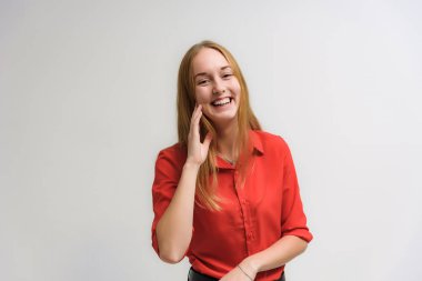 Stüdyo portre fotoğraf gülümseyen güzel bir kızın uzun saçlı beyaz bir arka plan duygu ile konuşurken. O çeşitli pozlar kamera önünde duruyor ve mutlu görünüyor.