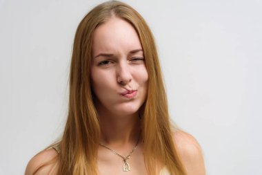 Stüdyo portre fotoğraf gülümseyen güzel bir kızın uzun saçlı beyaz bir arka plan duygu ile konuşurken. O çeşitli pozlar kamera önünde duruyor ve mutlu görünüyor.