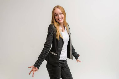 Stüdyo portre fotoğraf gülümseyen güzel bir kızın uzun saçlı beyaz bir arka plan duygu ile konuşurken. O çeşitli pozlar kamera önünde duruyor ve mutlu görünüyor.