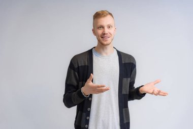 Beyaz arka planda konuşan gülümseyen bir gencin stüdyo portresi. Farklı pozlarda, farklı duygularla kameranın önünde duruyor..