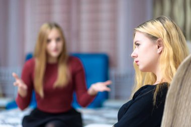 Aile sorunları kavramı iki güzel genç hoşnutsuz lezbiyen kız kanepede oturan bir odada konuşuyor. Kamera önünde doğru ve mutsuz bak.