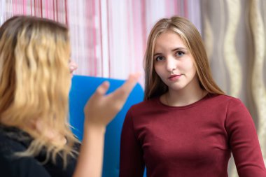 Aile sorunları kavramı iki güzel genç hoşnutsuz lezbiyen kız kanepede oturan bir odada konuşuyor. Kamera önünde doğru ve mutsuz bak.