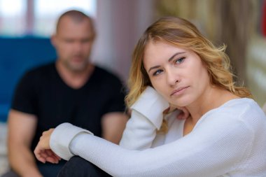 Aile sorunları genç karısı ve kocası kanepede. Onlar Oda sağ mutsuz seyir kamera önünde oturuyorlar.