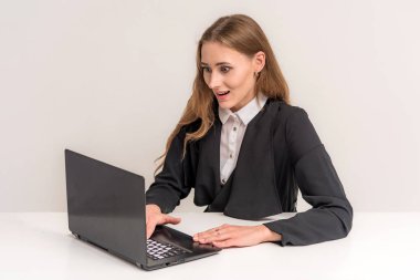 Bir dizüstü bilgisayar ile masada beyaz zemin üzerine güzel bir esmer kız portresi. Çeşitli teşkil etmektedir, kamera önünde gülümseyen ve mutlu görünüyordu duruyor.