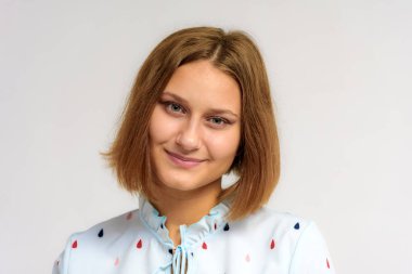 Beyaz bir arka plan üzerinde güzel bir genç kız portresi. Farklı duygular ile farklı pozlar kamera önünde bir kız.