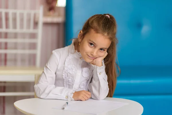 Ένα Χαριτωμένο Κοριτσάκι Κάθεται Ένα Τραπέζι Σχέδιο Και Λέει Κάτι — Φωτογραφία Αρχείου