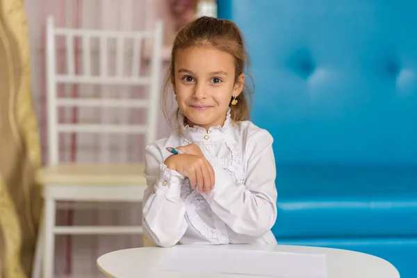 Ένα Χαριτωμένο Κοριτσάκι Κάθεται Ένα Τραπέζι Σχέδιο Και Λέει Κάτι — Φωτογραφία Αρχείου