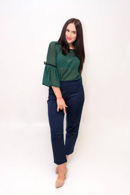 Tam büyüme beyaz zemin üzerine güzel bir esmer kız portresi. O doğrudan farklı pozlar kamera önünde duruyor ve farklı duygular gösterir