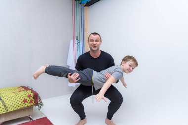 Aile her gün içinde odak: baba ve oğul yapmak Spotting. Evde spor. Yukarı üç aylık dönemde sıcak. Jimnastik mindere yalan. Spor yapıyor. Dostum ve oğlum evde Tren.