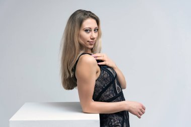 Beyaz bir arka plan üzerinde gülümseyen güzel sarışın kız portresi konsept ürünü tanıtır. O kamera önünde haklı ve farklı duygular gösterir.