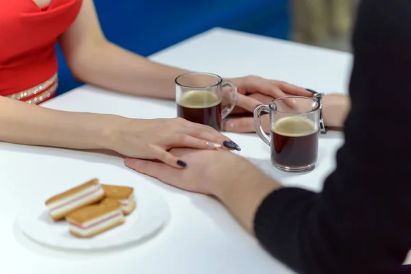 people sit at the table and drink coffee, they have a date