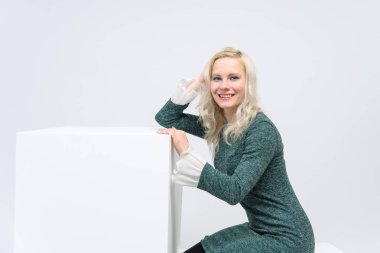 duran kadın kavramı beyaz bir arka plan beyaz küpleri ve kameraya baktığımızda, onlar are ortasında belgili tanımlık çerçevelemek ve Yeşil elbiseli bir kız gülümseyerek ve beyaz saçlı o makyaj vardır.