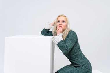 duran kadın kavramı beyaz bir arka plan beyaz küpleri ve kameraya baktığımızda, onlar are ortasında belgili tanımlık çerçevelemek ve Yeşil elbiseli bir kız gülümseyerek ve beyaz saçlı o makyaj vardır.